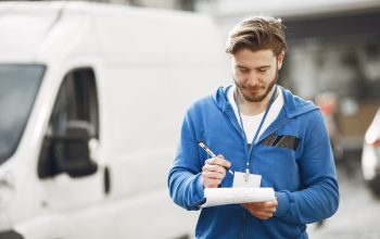 Man by the truck. Guy in a delivery uniform. Man with clipboard.
